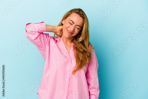 Caucasian woman isolated on blue background suffering neck pain due to sedentary lifestyle.