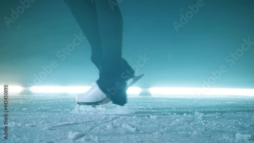 Slow motion of athlete's legs in skates spinning on the ice photo