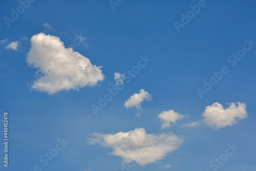 Beautiful cumulus clouds against the blue daytime sky.