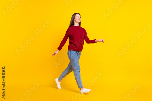 Full length body size view of attractive cheerful girl walking strolling isolated over bright yellow color background