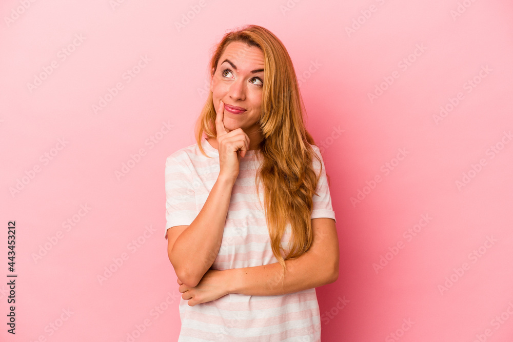 Caucasian blonde woman isolated on pink background contemplating, planning a strategy, thinking about the way of a business. Caucasian blonde woman isolated on pink background contemplating, planning a strategy, thinking about the way of a business.
