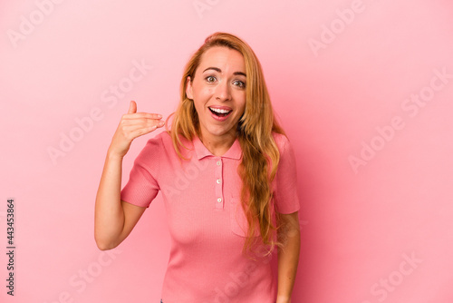 Caucasian blonde woman isolated on pink background laughing about something  covering mouth with hands.
