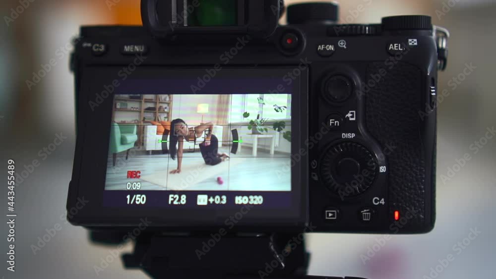 Camera recording woman working out on fitness mat with dumbbells. Close up blogger filming exercise Camera recording woman working out on fitness mat with dumbbells. Close up blogger filming exercise
