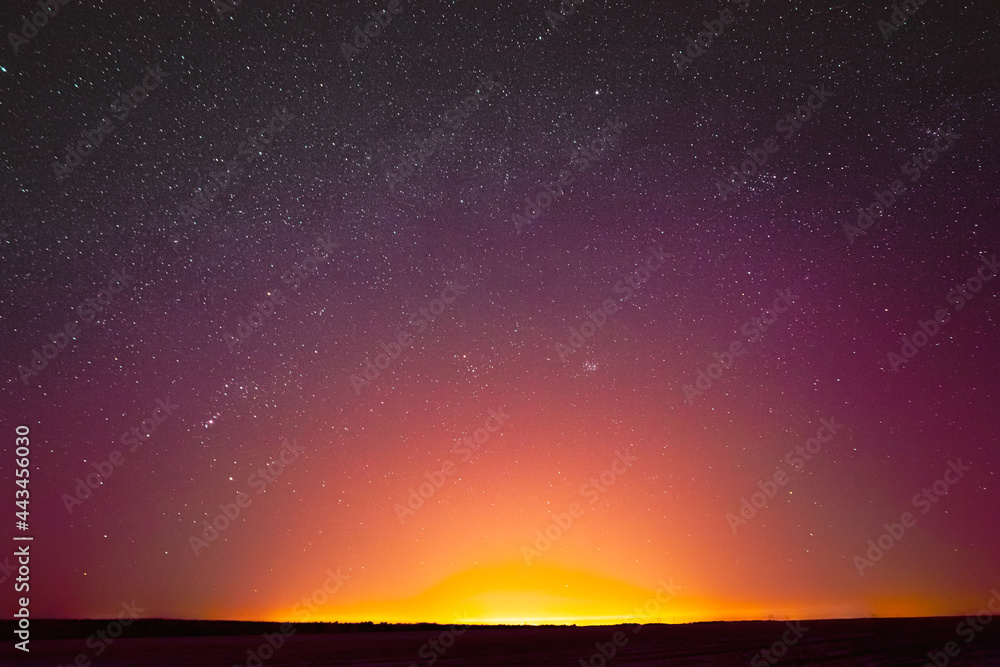 Colorful Night Sky With Glowing Stars Background Backdrop. Sky Gradient. Sunset, Sunrise Lights And Colourful Night Starry Sky In Yellow Pink Magenta Orange Purple Colors. Dark Ground Silhouette. Copy