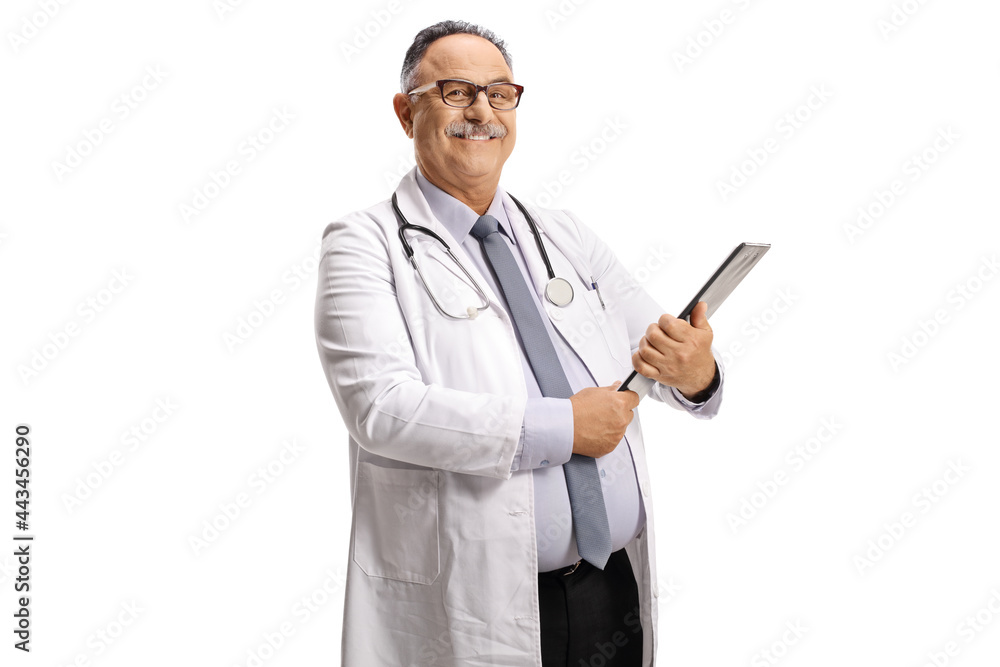 Smiling mature doctor standing and holding a clipboard Smiling mature doctor standing and holding a clipboard
