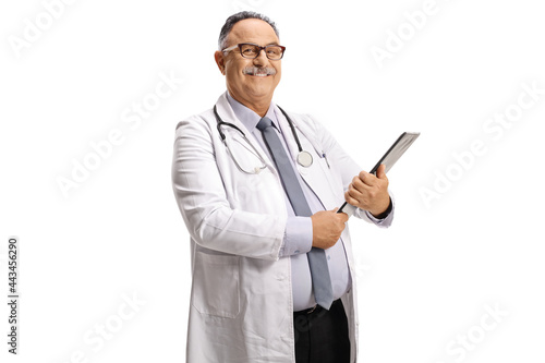 Smiling mature doctor standing and holding a clipboard