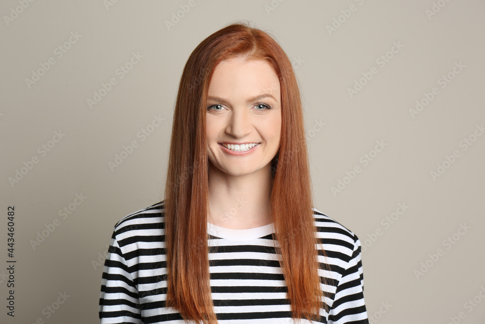 Candid portrait of happy young woman with charming smile and gorgeous red hair on beige background Candid portrait of happy young woman with charming smile and gorgeous red hair on beige background