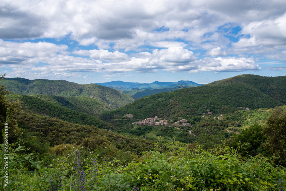 View into the landscape of the French Cevennes towards Saint Martial. Cloudy summer sky
