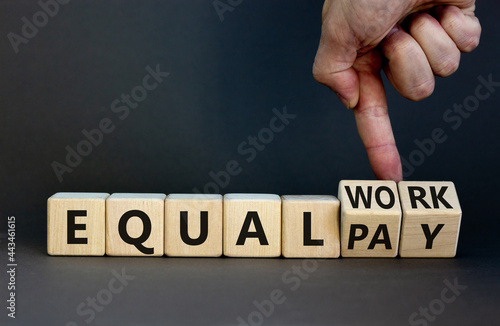 Equal pay and work symbol. Businessman turns wooden cubes and changes words equal pay to equal work. Beautiful grey background. Copy space. Business and equal pay and work concept. photo