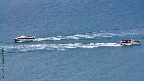 Two tourists boat cruising on the sea in opposite directions