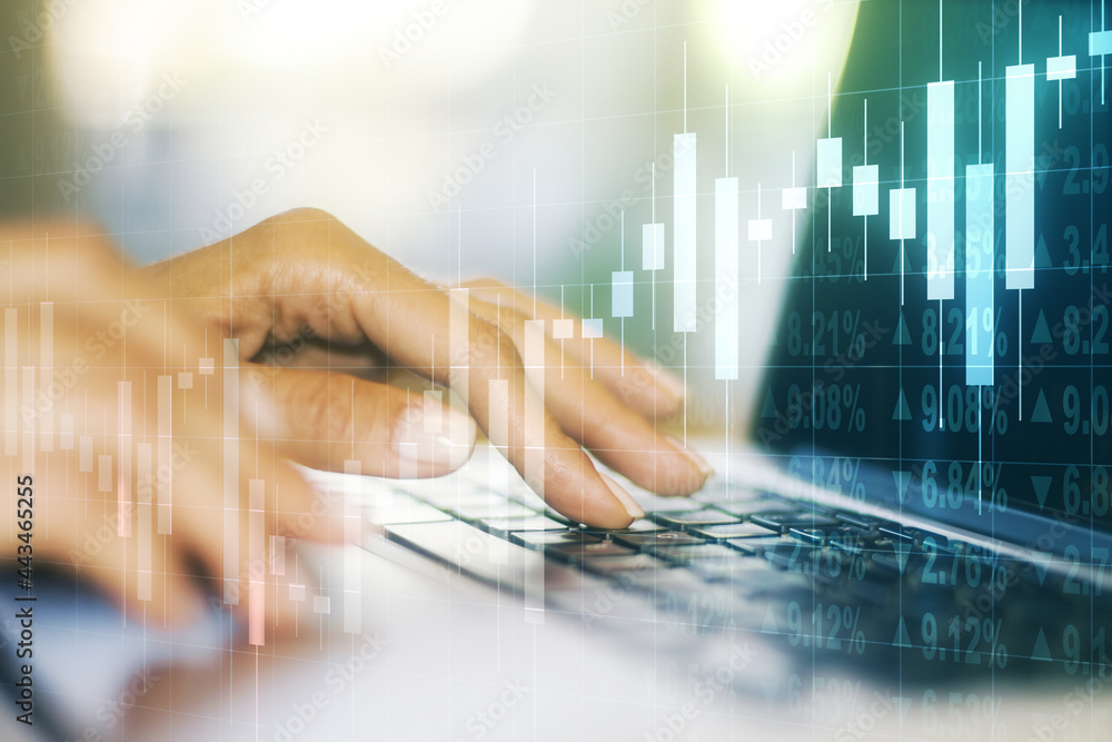 Multi exposure of abstract creative financial graph with hand typing on laptop on background, forex and investment concept Multi exposure of abstract creative financial graph with hand typing on laptop on background, forex and investment concept