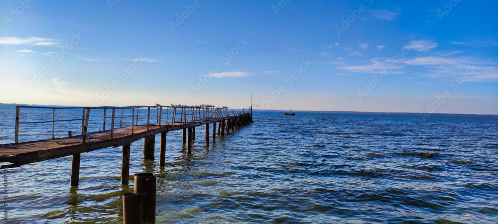 View of the old iron rusty pier in the estuary. Blue sky and water in Zatoka. Ukraine. Europe	