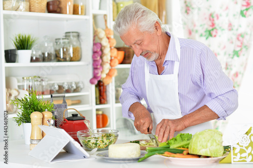 Portrait of senior man preparing dinner in kitchen