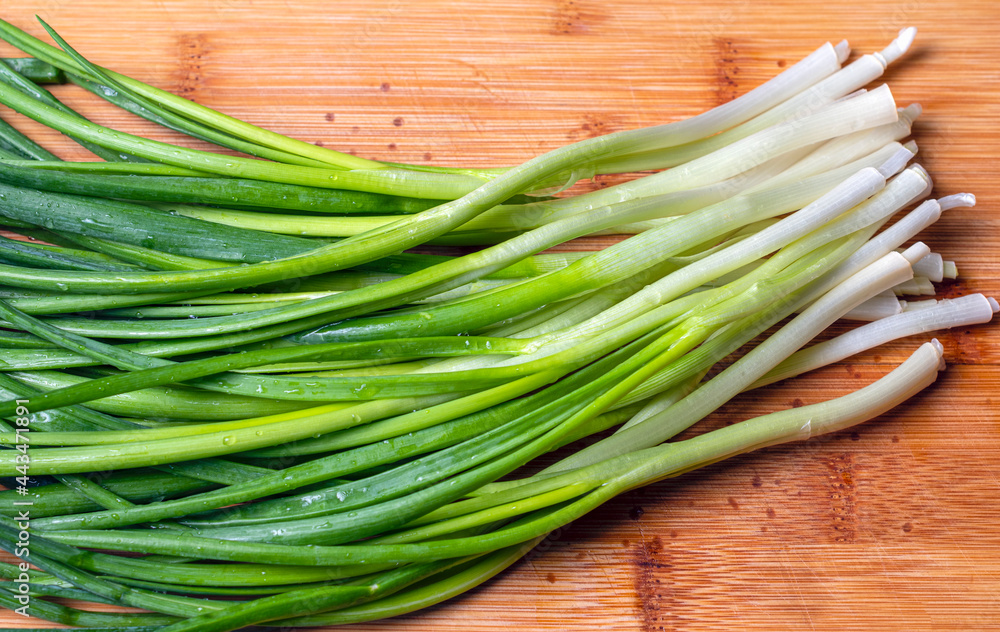 View from above of green spring onions on wooden background. View from above of green spring onions on wooden background.