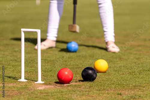 Bild auf Leinwand female croquet player hitting the ball with mallet