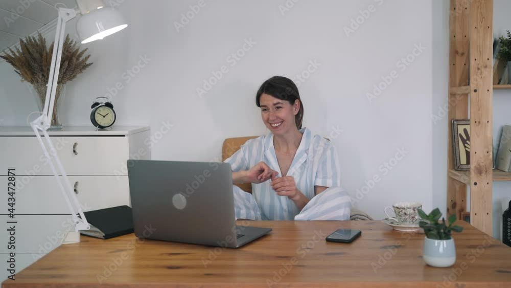 A young woman communicates online. A woman in pajamas is sitting at a laptop. Freelance. Self-isolation. Business lady. Work at home. Online consultation. Home schooling Online courses A young woman communicates online. A woman in pajamas is sitting at a laptop. Freelance. Self-isolation. Business lady. Work at home. Online consultation. Home schooling Online courses