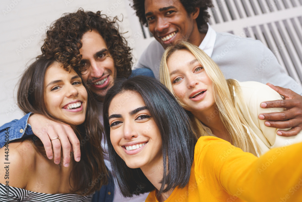 Multi-ethnic group of friends taking a selfie together while having fun outdoors. Multi-ethnic group of friends taking a selfie together while having fun outdoors.