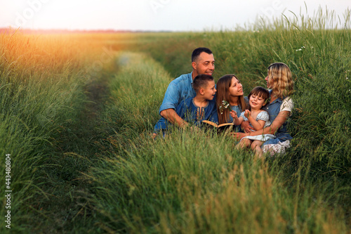 Canvas Print young family with children reading the Bible in nature