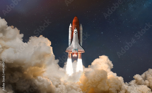 Space shuttle launch in the clouds to outer space. Dark space with stars on background. Sky and clouds. Spaceship flight. Elements of this image furnished by NASA