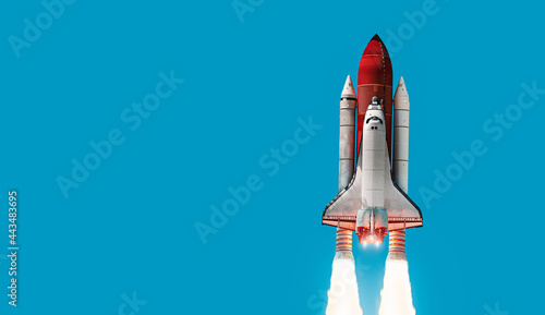 Space shuttle on blue background. Rocket in the sky. Space ship in space. Elements of this image furnished by NASA
