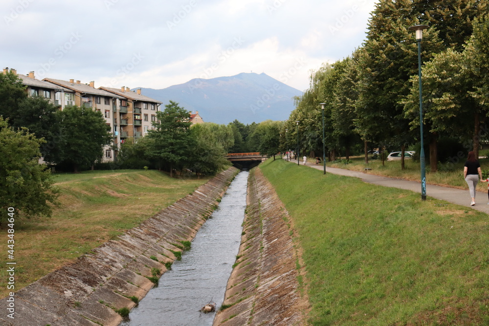 Small suburb river with mountain in the background