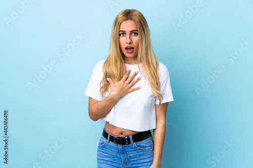Young Uruguayan blonde woman over isolated blue background pointing to oneself