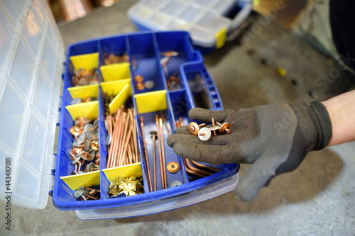 Worker choose a screws from the box, close-up of hand wearing in work glove. Do it yorself. photo