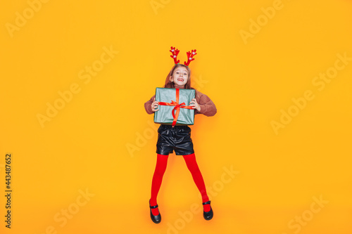 Girl holding gift in front of yellow background