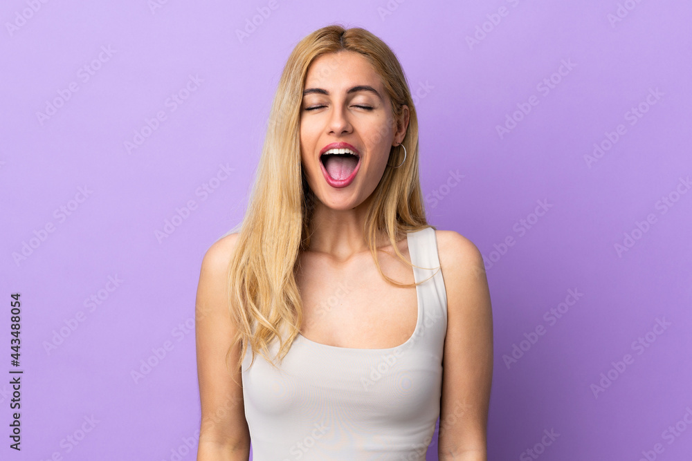 Young Uruguayan blonde woman over isolated background shouting to the front with mouth wide open