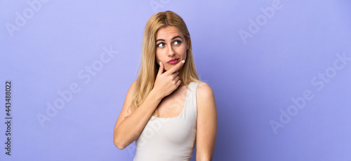 Young Uruguayan blonde woman over isolated background having doubts and with confuse face expression