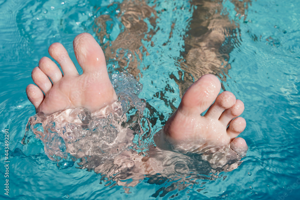 Toes peeking out of the water. Foot with the pool background. Toes close up