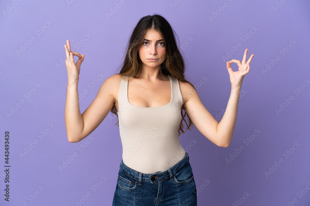 Young caucasian woman isolated on purple background in zen pose Young caucasian woman isolated on purple background in zen pose