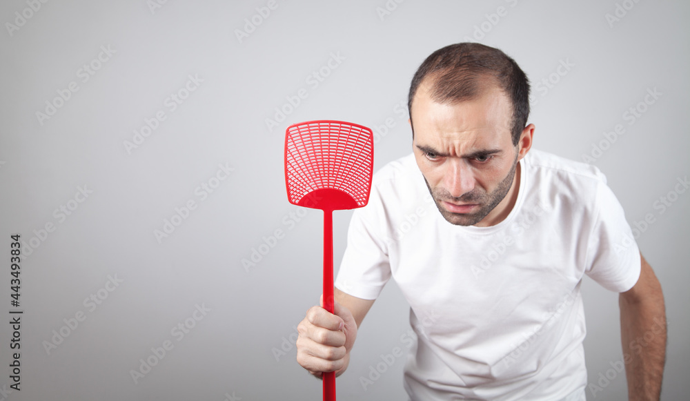 Caucasian man holding a fly swatter.