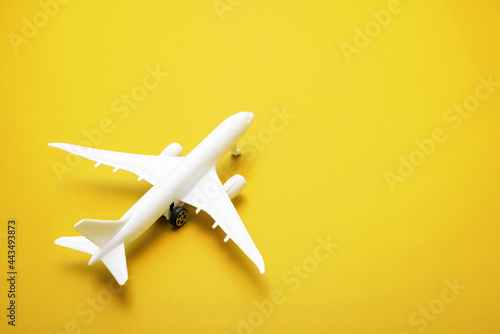 White model of passenger plane on yellow background , travel concept. Traveling by plane