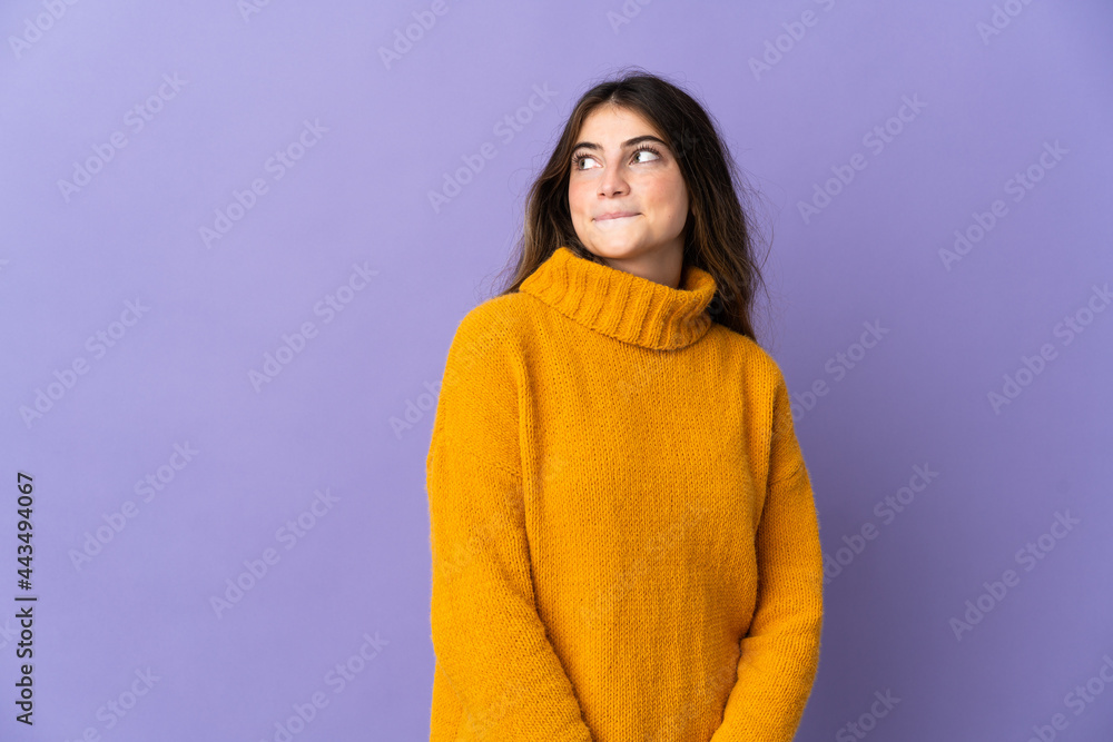 Young caucasian woman isolated on purple background having doubts while looking up Young caucasian woman isolated on purple background having doubts while looking up