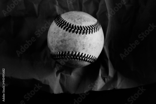 Photography Dark moody baseball ball on texture black and white background.