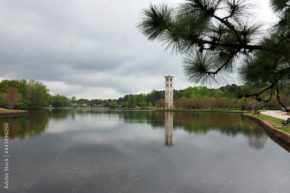 Obraz premium View of bell clock tower on island in center of lake pond