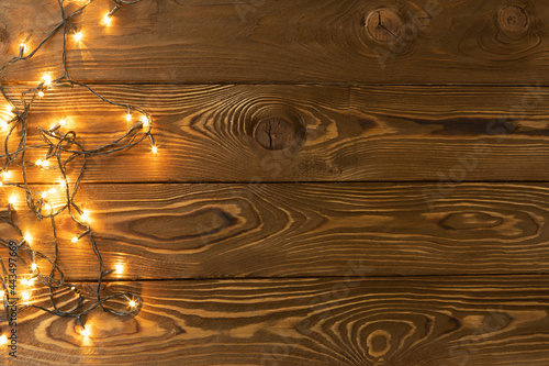 Wallpaper Mural Christmas background. Glowing garlands on brown wooden planks, one side. Copy space, flat lay, top view. Holiday, Xmas, New Year, party concept, layout with place for text. Horizontal Torontodigital.ca