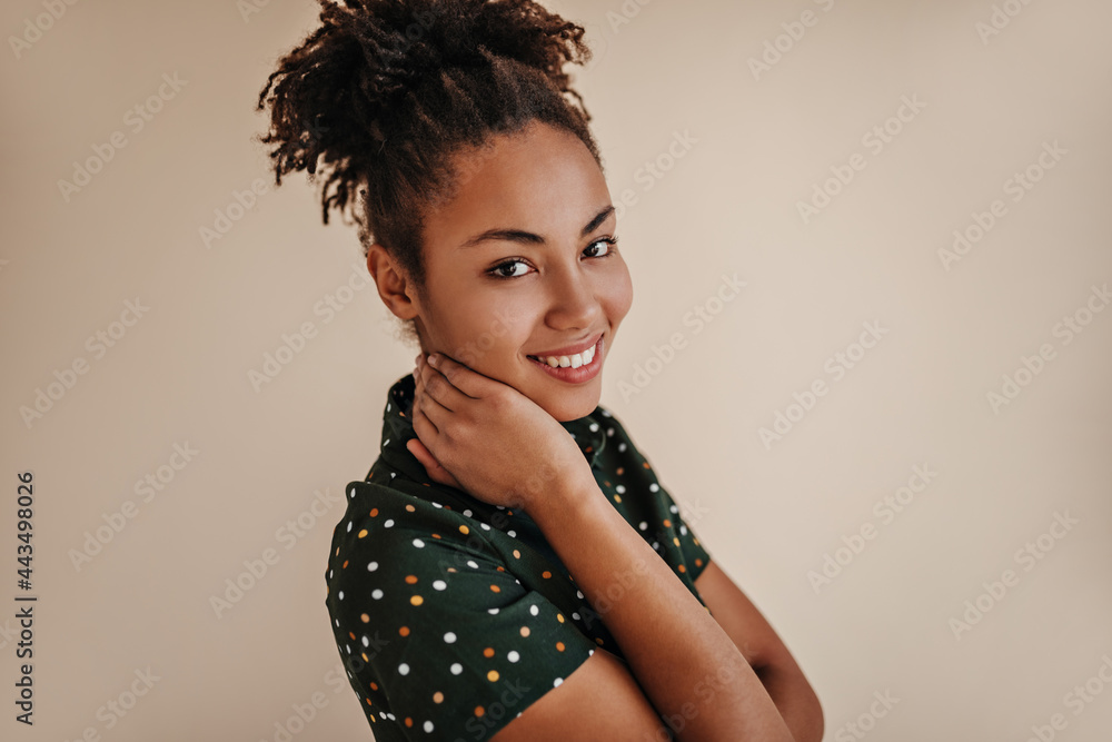 Cute african woman in green attire smiling at camera. Studio shot of glad black girl. Cute african woman in green attire smiling at camera. Studio shot of glad black girl.