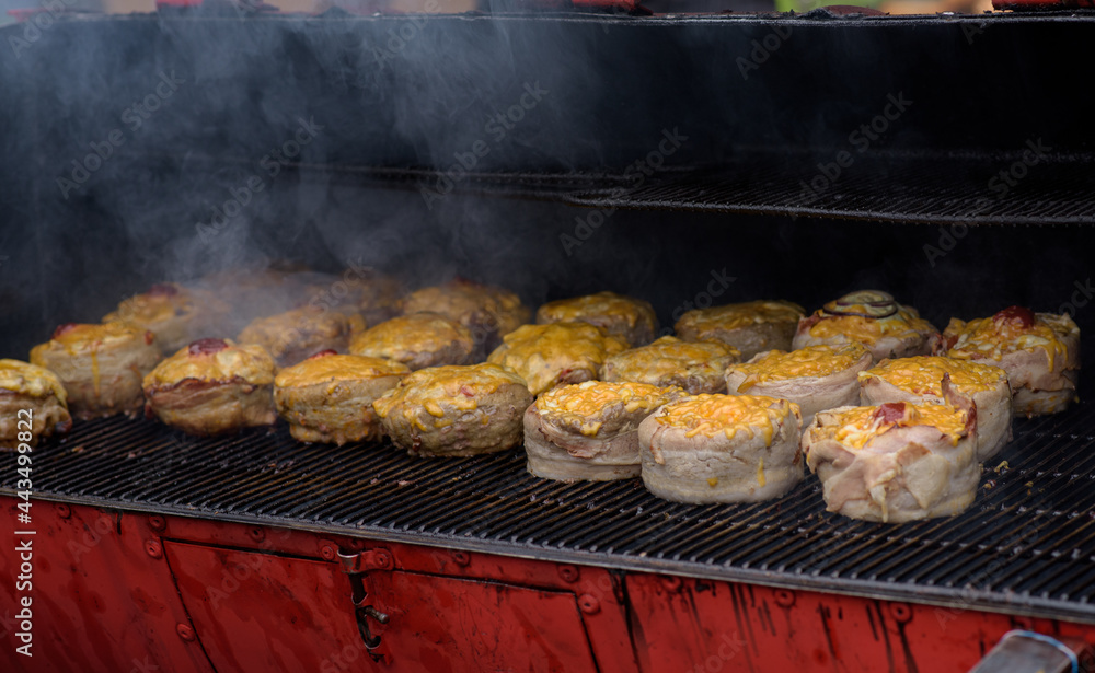Handmade hamburger patties during the street food festival, smoke while cooking. Handmade hamburger patties during the street food festival, smoke while cooking.