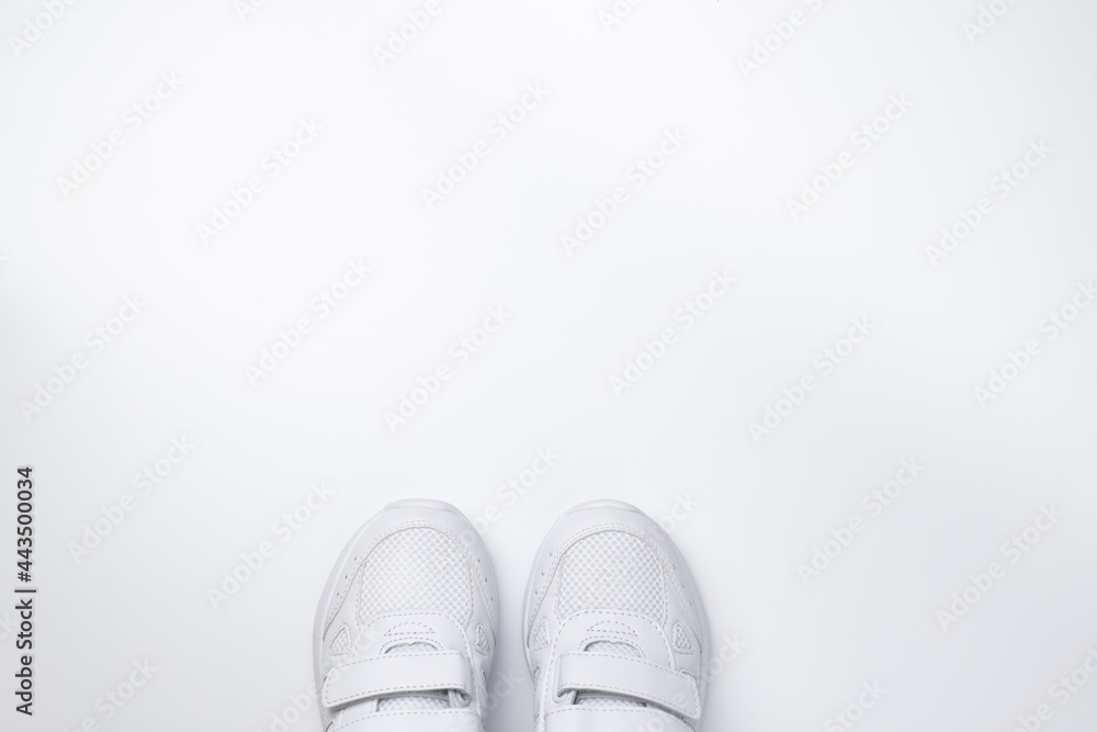 flat lay two white sneakers partially located at the bottom in the center with free space for text isolated on a white background. flat lay two white sneakers partially located at the bottom in the center with free space for text isolated on a white background.