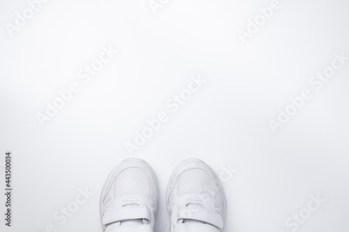 flat lay two white sneakers partially located at the bottom in the center with free space for text isolated on a white background.