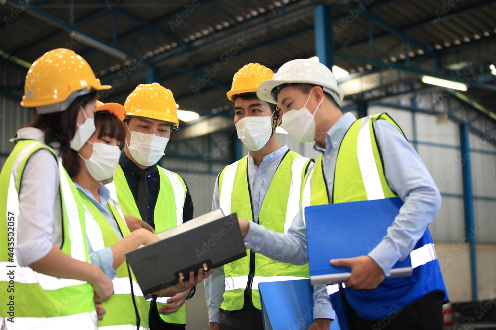 Team workers wear protective face masks for safety industrial factory. worker meeting before start working in factory or warehouse Team workers wear protective face masks for safety industrial factory. worker meeting before start working in factory or warehouse