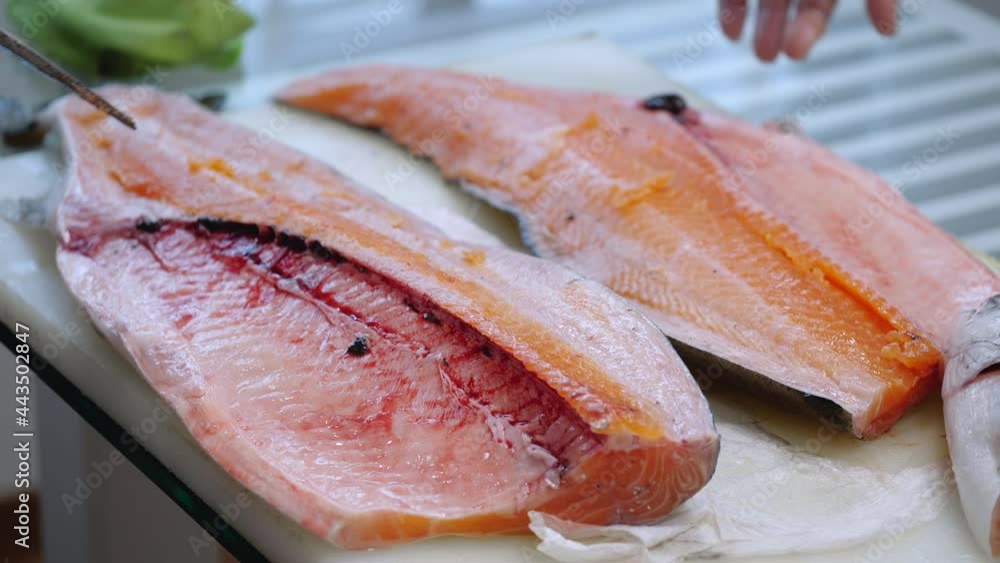 The chef is using a knife to fillet salmon The chef is using a knife to fillet salmon