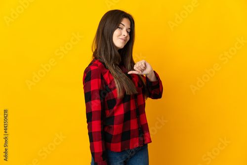 Teenager Brazilian girl isolated on yellow background proud and self-satisfied © luismolinero