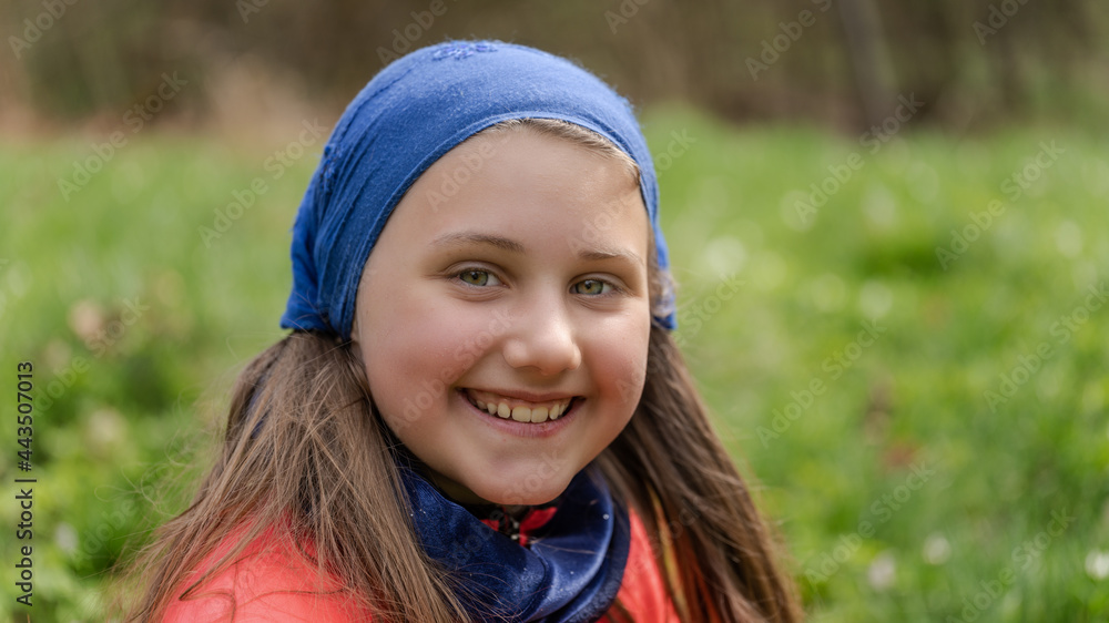 Porträt eines jungen, hübschen, nachdenklich Mädchens mit blauem Kopftuch im Wald. Lebensfreude, Glück, Gesundheit, Freiheit sind Motivation in der grünen, blühenden Natur. Porträt eines jungen, hübschen, nachdenklich Mädchens mit blauem Kopftuch im Wald. Lebensfreude, Glück, Gesundheit, Freiheit sind Motivation in der grünen, blühenden Natur.
