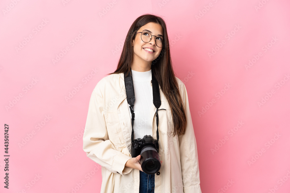 Young photographer Brazilian girl isolated on pink background thinking an idea while looking up Young photographer Brazilian girl isolated on pink background thinking an idea while looking up