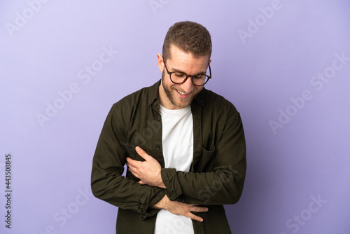 Young handsome caucasian man isolated on purple background smiling a lot © luismolinero