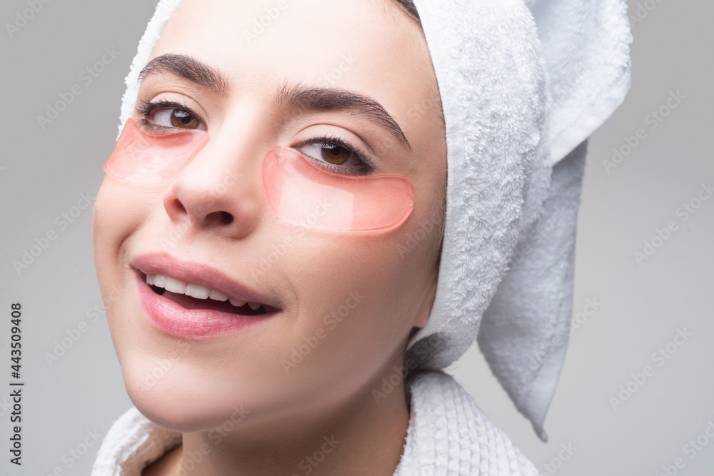 Close up portrait girl with towel on head. Portrait of beauty woman with eye patches showing an effect of perfect skin. Brunette spa girl. Eyes mask cosmetic patches woman face closeup. Close up portrait girl with towel on head. Portrait of beauty woman with eye patches showing an effect of perfect skin. Brunette spa girl. Eyes mask cosmetic patches woman face closeup.