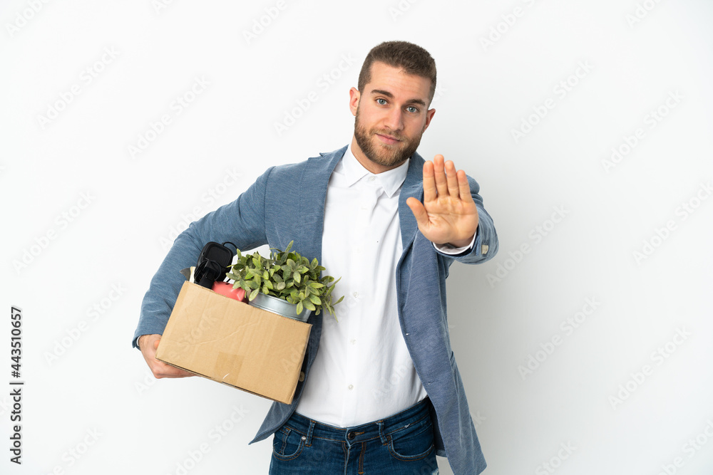 Young caucasian making a move while picking up a box full of things isolated on white background making stop gesture Young caucasian making a move while picking up a box full of things isolated on white background making stop gesture